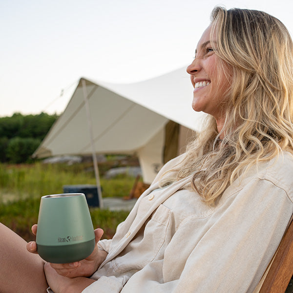 Woman smiling with wine tumbler in hand